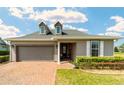 Charming one-story home featuring a brick driveway, well-manicured landscaping, and a two-car garage at 5111 Nw 35Th Pl, Ocala, FL 34482
