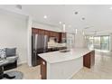 Modern kitchen with stainless steel appliances, dark wood cabinets, and large island with sink at 5870 Sw 93Rd Cir, Ocala, FL 34481