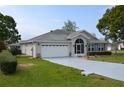 Exterior of a one-story home with a well-maintained lawn, two-car garage, and screened entryway at 6548 Sw 84Th Place Rd, Ocala, FL 34476