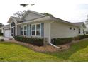 Angled exterior view showcasing the home's side and front, blue shutters, and foundation plantings at 6548 Sw 84Th Place Rd, Ocala, FL 34476