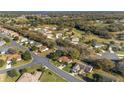 Aerial view showing the homes in the neighborhood and the nearby golf course and landscape at 8740 Se 140Th Place Rd, Summerfield, FL 34491