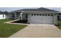 Beautiful single-story home with a two-car garage and a well-maintained lawn and landscaping at 9455 Se 152Nd Pl, Summerfield, FL 34491