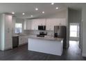 Bright kitchen with white cabinets, stainless steel appliances, and a center island, offering ample counter space at 9455 Se 152Nd Pl, Summerfield, FL 34491