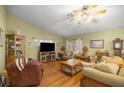 Cozy living room featuring hardwood floors, comfortable seating, and a ceiling fan at 9710 Sw 96Th St, Ocala, FL 34481