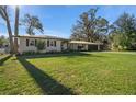 Charming single-story home features a lush green lawn, attached garage, and mature trees at 1732 Se 38Th Ct, Ocala, FL 34471