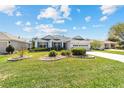 Well-maintained single-story home with a lush green lawn and landscaped garden beds at 1854 Oxford Lane, The Villages, FL 32162