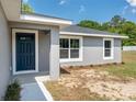 A home's front entrance, featuring a blue front door and modern gray exterior at 2 Hemlock Ter Dr, Ocala, FL 34472