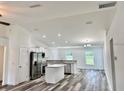 Open concept kitchen with white cabinets, stainless steel appliances, and eat-in island at 3 Dogwood Drive Loop, Ocala, FL 34472