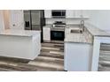 Modern kitchen featuring white cabinets, granite countertops, and stainless steel appliances at 3 Dogwood Drive Loop, Ocala, FL 34472