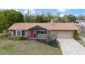 Charming brick home with a well-maintained lawn, red door, and two-car garage at 6136 Se 37Th Ter, Ocala, FL 34480