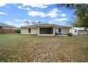 Spacious backyard featuring a large grassy area, mature trees, and screened in patio at 6718 Cherry Rd, Ocala, FL 34472