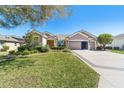 Charming home featuring manicured landscaping, a three-car garage, and a well-maintained lawn at 6865 Sw 97Th Terrace Rd, Ocala, FL 34481