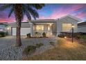 Charming home featuring a manicured lawn, paved walkway, and lovely landscaping with a palm tree at dusk at 9974 Sw 88Th Loop, Ocala, FL 34481