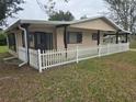 Home exterior showing a well-maintained lawn and charming white picket fence at 10040 Sw 98Th Ave, Ocala, FL 34481