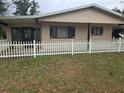 Charming home exterior featuring a well-kept lawn and classic white picket fence at 10040 Sw 98Th Ave, Ocala, FL 34481
