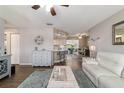 Open concept living room with wood floors, soft gray furniture, and a breakfast bar overlooking the kitchen and dining area at 11475 Sw 85Th Ave, Ocala, FL 34481