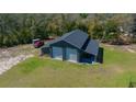 Large detached garage with roll-up doors and covered patio at 11707 Se 101St Court Rd, Belleview, FL 34420