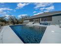 Sparkling in-ground pool with a sun shelf and deck seating at 11707 Se 101St Court Rd, Belleview, FL 34420