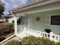 Inviting front porch with white railing and green accents, adorned with a decorative sun at 14191 Sw 115Th Ter, Dunnellon, FL 34432