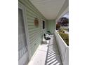 Comfortable and shady front porch area with two chairs and a small table at 14191 Sw 115Th Ter, Dunnellon, FL 34432