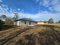 Rear view of a single-story home with a sliding glass door and ample backyard space at 15 Locust Trak, Ocala, FL 34472