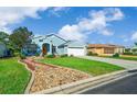Charming blue home with well-manicured lawn, rock garden and attached two-car garage at 15092 Sw 14Th Avenue Rd, Ocala, FL 34473