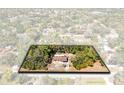 Aerial view showcasing the home surrounded by lush, mature trees and a well-maintained landscape at 1533 Pine St, Apopka, FL 32703