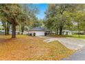 Single-story home featuring mature trees, an attached two-car garage, and a well-kept lawn at 31 Redwood Rd, Ocala, FL 34472