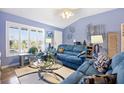 Cozy living room with a large window, comfortable blue seating, and stylish decor at 3407 Melbourne Ln, The Villages, FL 32163