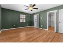 Bedroom featuring wood floors, natural light, and an adjacent walk-in closet at 5615 Se 113Th Pl, Belleview, FL 34420