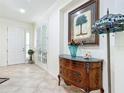 Elegant foyer with tile flooring, decorative console table, and bright lighting at 7527 Sw 97Th Terrace Rd, Ocala, FL 34481