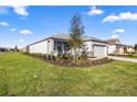 Well-maintained home exterior featuring lush landscaping and an expansive lawn on a sunny day at 8802 Sw 79Th Loop, Ocala, FL 34481