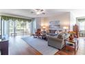 Inviting living room boasts wood floors, neutral paint, and views of the screened lanai at 9458 Sw 93Rd Loop, Ocala, FL 34481
