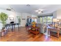 Spacious living area showcasing wood floors, a ceiling fan, and seamless transition to the dining area at 9458 Sw 93Rd Loop, Ocala, FL 34481