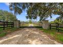 Grand gated entrance to the horse farm, with ornate metalwork and stone pillars, hinting at the property's elegance and privacy at 13800 Ne Jacksonville Road, Citra, FL 32113