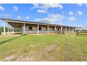 Spacious horse barn with multiple stalls and a covered area, providing shelter and comfort for the animals at 13800 Ne Jacksonville Road, Citra, FL 32113