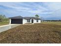 Charming single-story home featuring a black garage door, crisp white exterior, and manicured lawn at 17 Laurel Pass Ln, Ocala, FL 34480