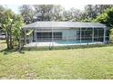 Screened-in pool provides a private outdoor oasis surrounded by lush green lawn at 1764 Se 169Th Avenue Rd, Silver Springs, FL 34488