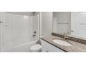 Bathroom featuring a granite countertop, a toilet, a shower and tub combo with white tiled walls at 211 Oak Lane Cir, Ocala, FL 34472