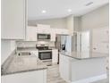 Modern kitchen featuring white cabinets, stainless steel appliances, and granite countertops at 211 Oak Lane Cir, Ocala, FL 34472