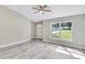 Bright living room with gray vinyl floors and a large window providing ample natural light at 211 Oak Lane Cir, Ocala, FL 34472