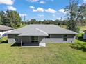 View of rear exterior highlighting the backyard, the light grey paint and the grey shingles at 217 Oak Lane Cir, Ocala, FL 34472