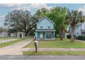 Charming two-story home with a light blue exterior, inviting front porch, and well-manicured lawn at 307 Nw 10Th Ave, Ocala, FL 34475