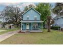 Charming two-story home with a light blue exterior, inviting front porch, and well-manicured lawn at 307 Nw 10Th Ave, Ocala, FL 34475