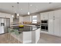 A modern kitchen with stainless steel appliances, a granite island, pendant lighting and white cabinetry at 4546 Nw 53Rd Avenue Rd, Ocala, FL 34482