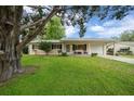 Charming single-story home with a well-maintained lawn and classic features, framed by a large tree at 6385 Sw 61St Ct, Ocala, FL 34474