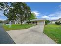 Well-manicured front yard and a long driveway leading up to a charming single-story home on a sunny day at 6385 Sw 61St Ct, Ocala, FL 34474