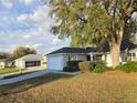 Lovely single-story home featuring an attached garage, mature trees, and a pristine yard at 6767 Sw 114Th Street Rd, Ocala, FL 34476