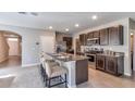Kitchen with granite counters, stainless appliances, dark cabinets, and bar stool seating at 8658 Sw 44Th Ter, Ocala, FL 34476