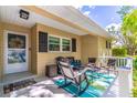 Inviting front porch with seating area, a welcome mat and a decorative wreath at 9380 Sw 84Th Ter # E, Ocala, FL 34481